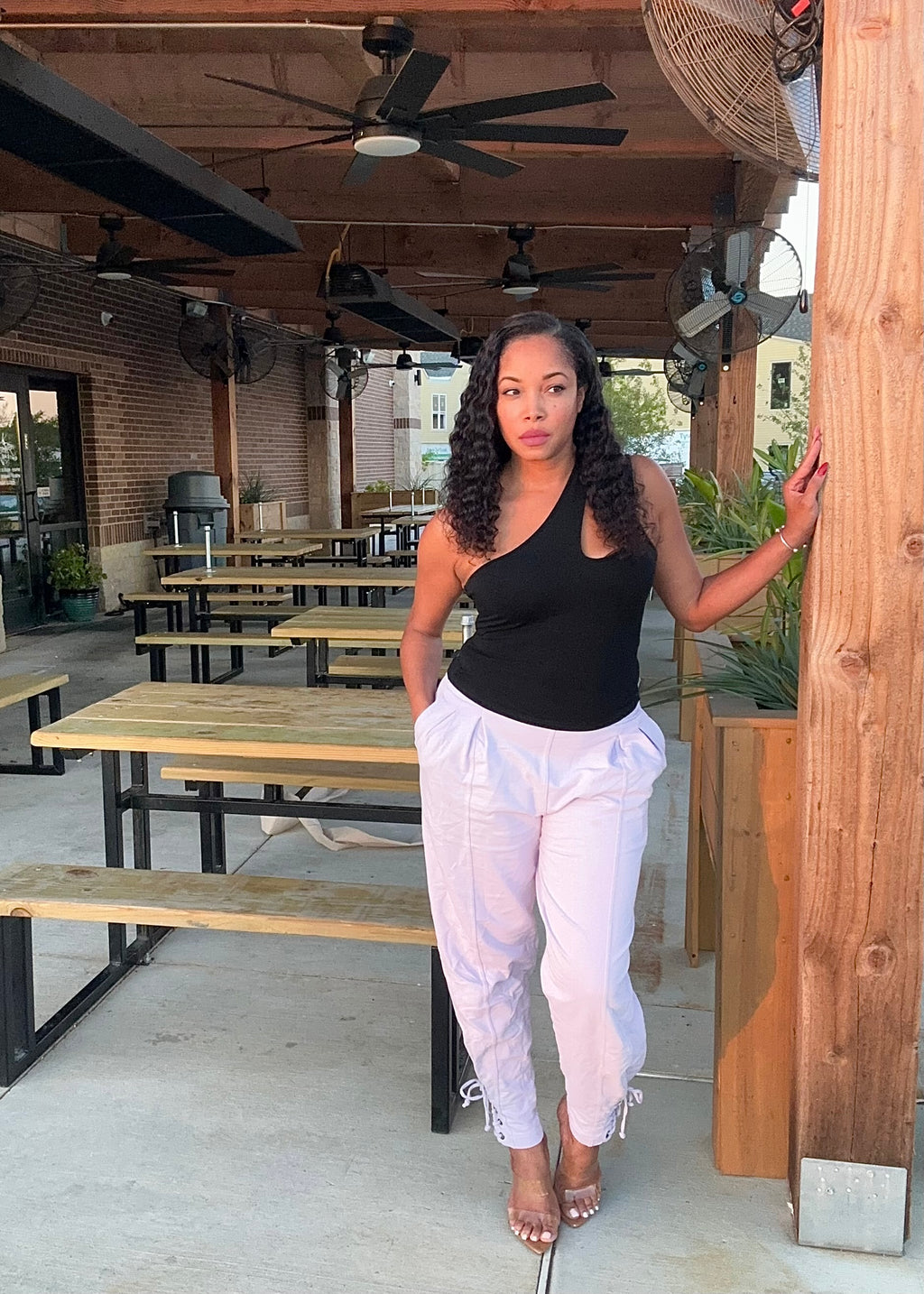 Woman standing outdoors near wooden tables and benches